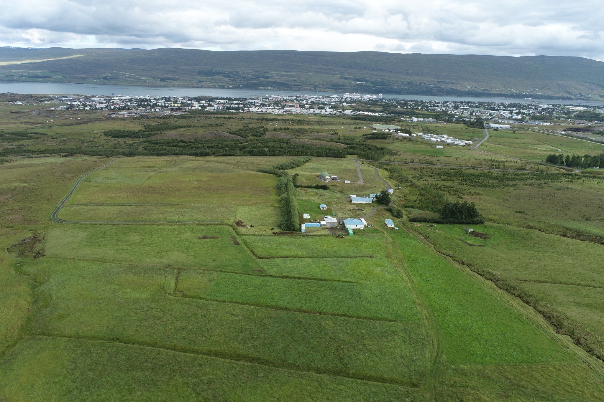 Loftmynd af Hesjuvöllum með Akureyri og Eyjafjörð í bakgrunni